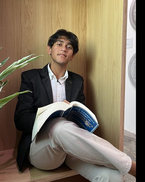 Ruddy Elan Bhujun, founder of ERB Academy, reading in a wooden nook.
